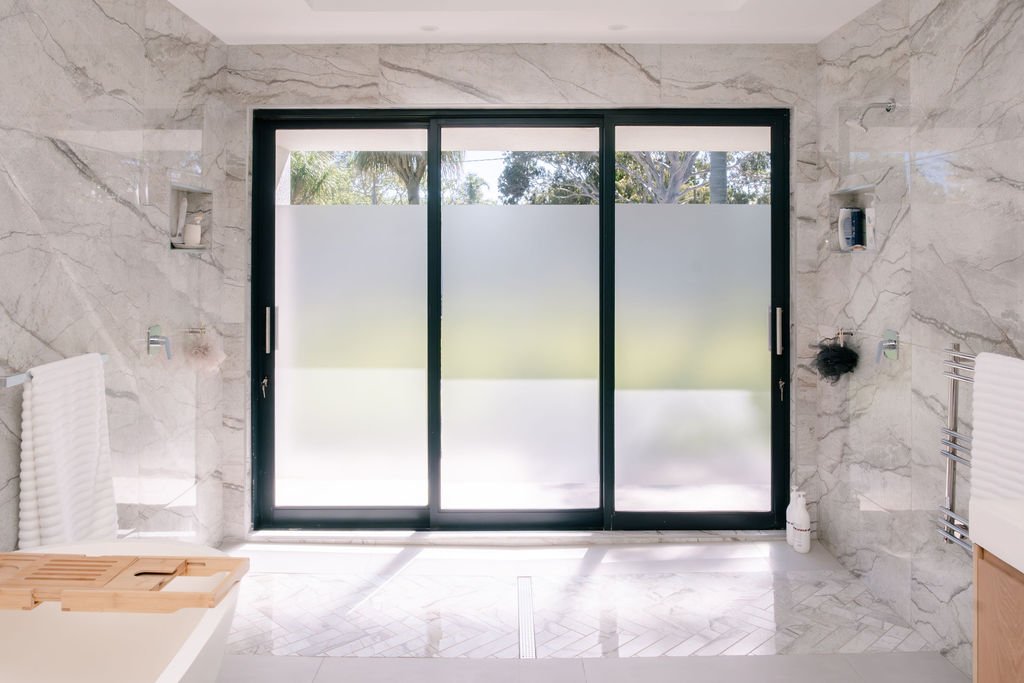 Marble bathroom with frosted aluminium doors